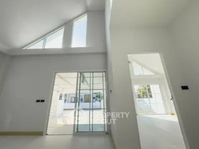 Spacious modern interior with high ceilings and large windows, offering abundant natural light and open space.