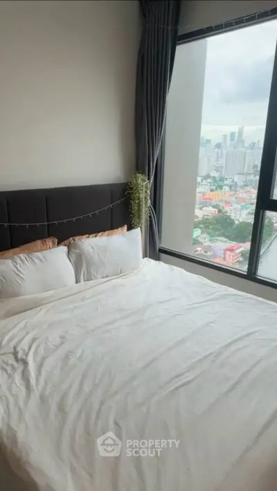 Cozy bedroom with stunning city view from large window, featuring a comfortable bed and elegant decor.