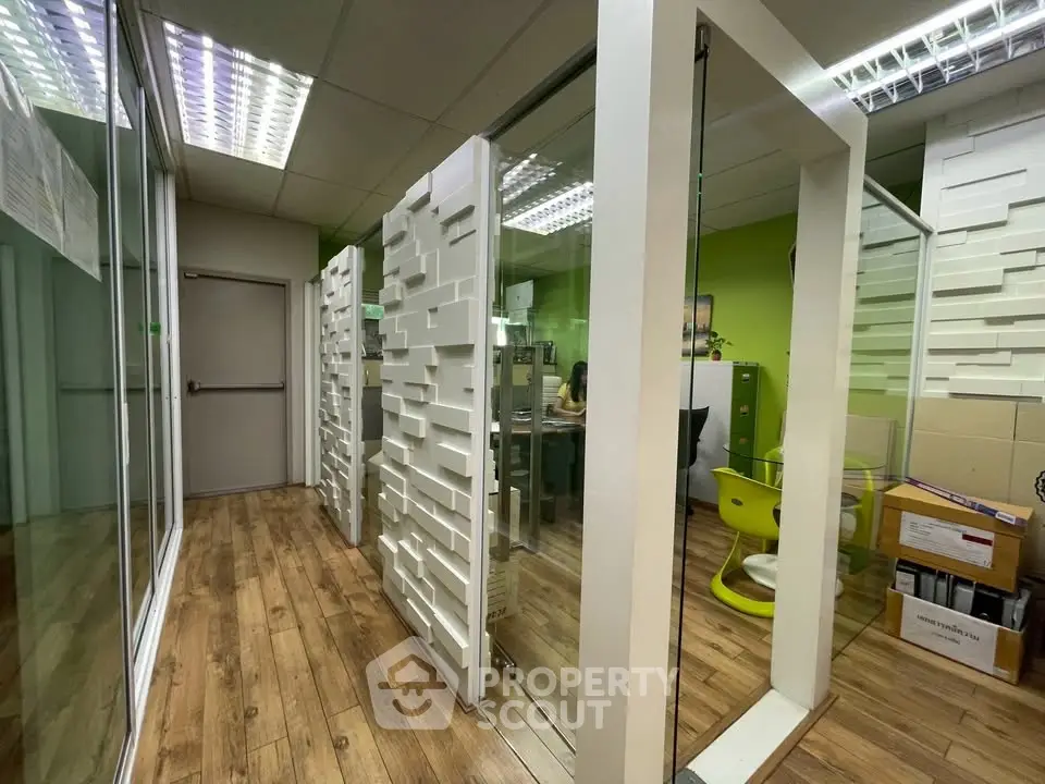 Modern office space with glass partitions and wooden flooring