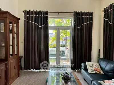 Spacious living room with elegant curtains and glass door leading to a garden view.