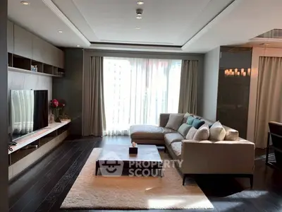 Luxurious modern living room with large sofa, stylish decor, and ample natural light from floor-to-ceiling windows.