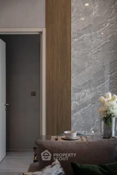Elegant modern living room with marble accent wall and stylish decor