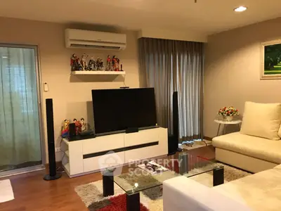 Stylish living room with modern decor, featuring a large TV, cozy sofa, and elegant curtains.