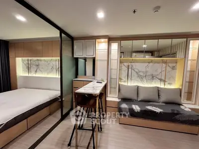 Modern studio apartment with stylish marble accents and cozy seating area.
