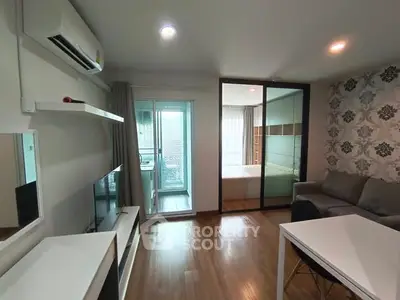 Modern living room with stylish decor and sliding glass doors leading to a cozy bedroom.