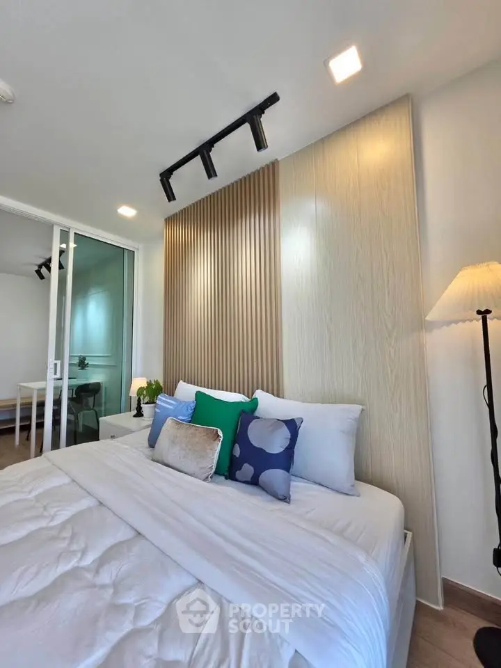 Modern bedroom with stylish decor and cozy bedding in a contemporary apartment.