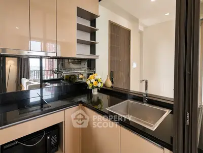 Modern kitchen with sleek black countertops and open layout in luxury apartment.