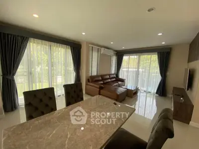 Spacious living room with modern furniture and large windows for natural light.