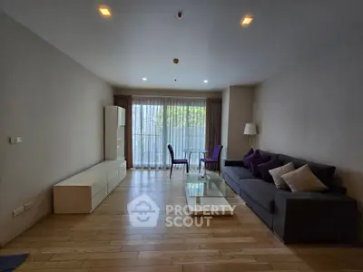 Spacious living room with modern furniture and large window for natural light.