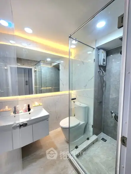 Modern bathroom with glass shower and sleek fixtures in luxury apartment.