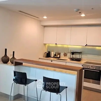 Modern kitchen with sleek design, featuring an open layout and stylish bar seating.