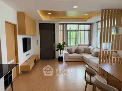 Modern living room with wooden accents and large windows offering natural light.