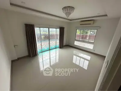 Spacious empty living room with large windows and garden view