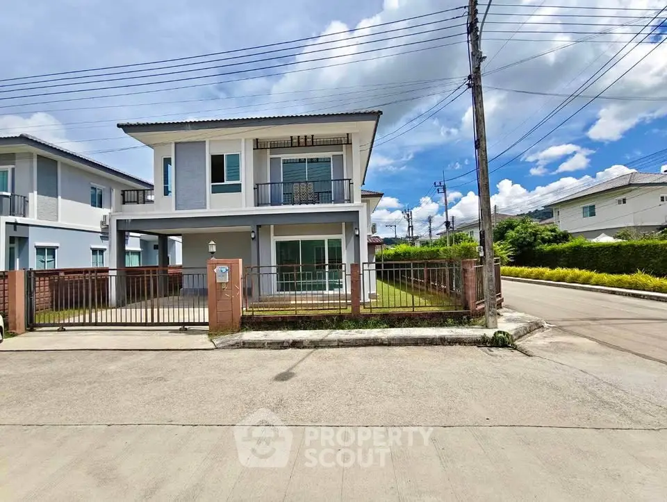 Modern two-story house with spacious yard and gated entrance in a serene neighborhood.