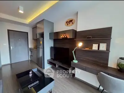 Modern living room with sleek furniture and integrated kitchen area.