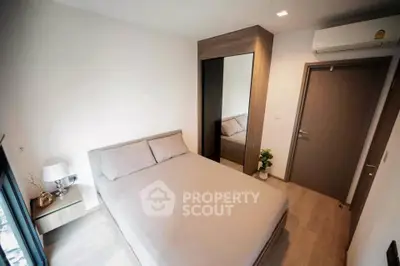 Cozy modern bedroom with sleek design and mirrored wardrobe in a stylish apartment.