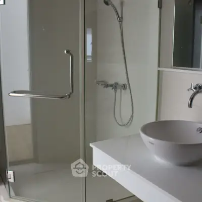 Modern bathroom with glass shower and sleek white sink