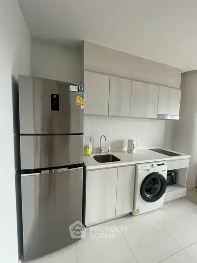Modern kitchen with sleek appliances and washing machine in stylish apartment