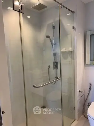 Modern bathroom with glass shower enclosure and sleek fixtures