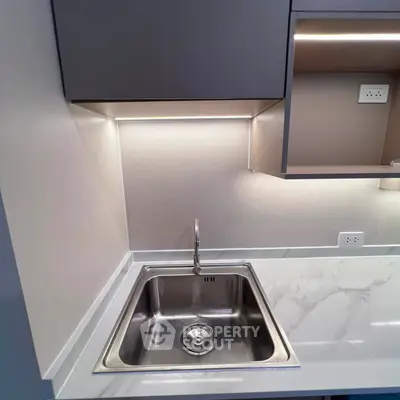 Modern kitchen with sleek stainless steel sink and elegant marble countertop