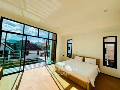 Spacious bedroom with large windows and balcony offering stunning views