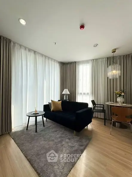 Modern living room with elegant decor, featuring a plush sofa, stylish table, and chic lighting.