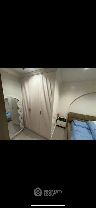 Stylish bedroom with modern wardrobe and cozy bed in elegant apartment.
