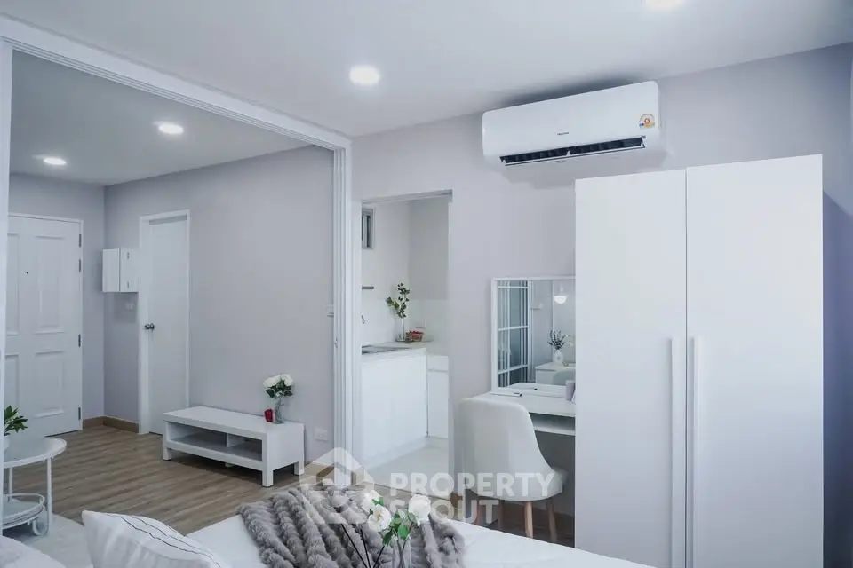 Modern studio apartment with sleek white furniture and open layout