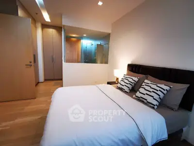 Modern bedroom with stylish decor and glass partition to bathroom