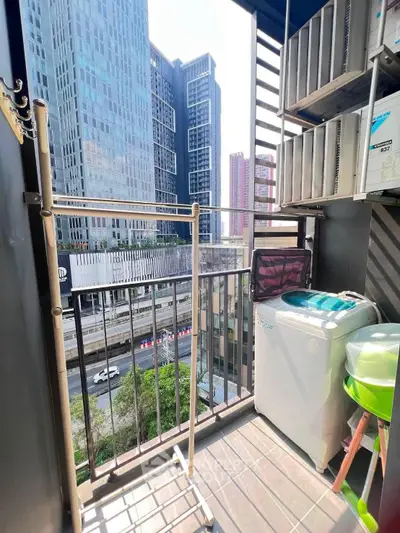 Charming urban balcony with city view, featuring laundry area and storage shelves, perfect for modern living.