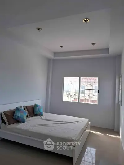 Bright and airy bedroom with modern design and large window offering natural light.