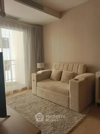 Cozy living room with beige sofa and natural light from balcony window