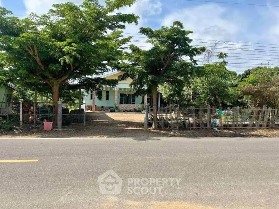 Charming countryside home with lush greenery and spacious front yard.
