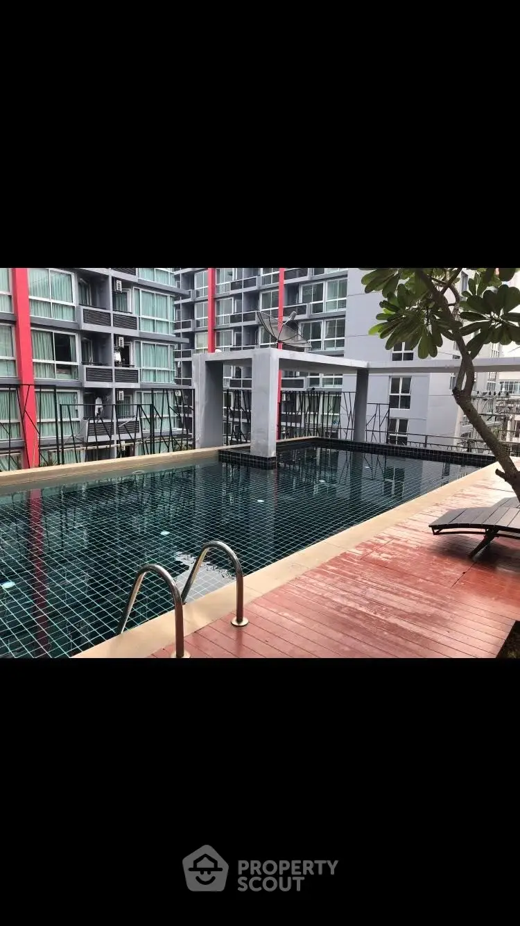 Modern apartment complex with rooftop pool and city view.