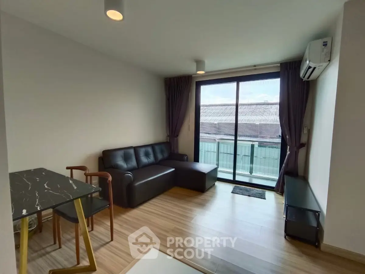 Modern living room with sleek furniture and balcony view, perfect for urban living.