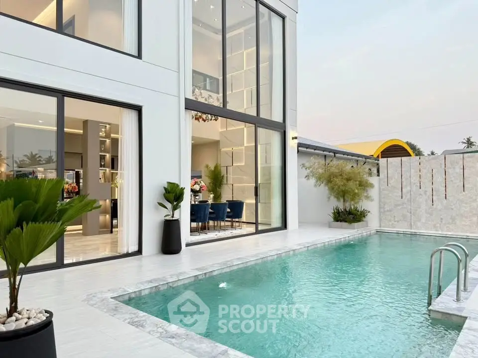 Luxurious modern home with elegant poolside and spacious glass windows