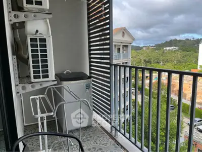 Charming balcony with scenic view and modern air conditioning units, perfect for relaxation.