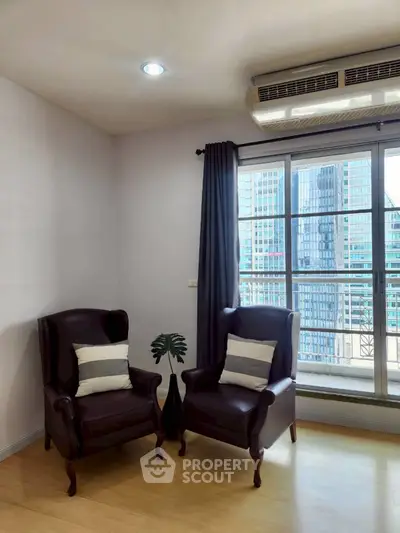 Stylish living room with elegant armchairs and city view through large window.