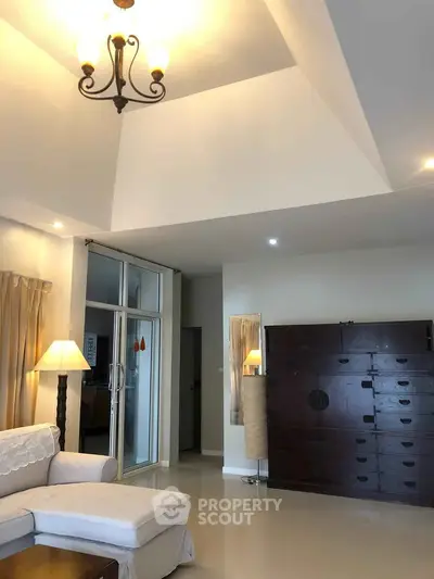 Spacious living room with high ceiling and elegant chandelier