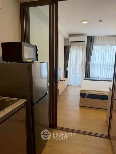 Modern studio apartment with kitchenette and cozy bedroom area