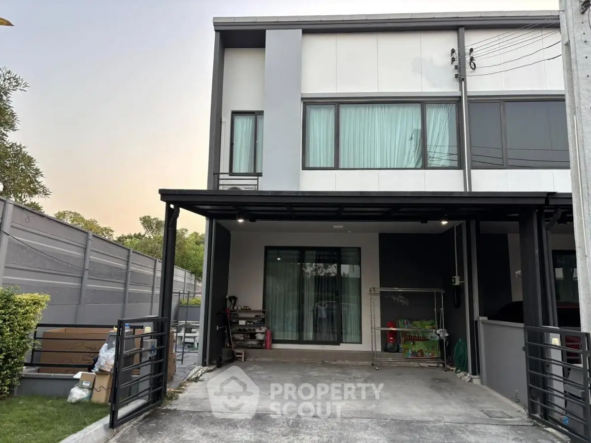 Modern townhouse exterior with driveway and large windows, perfect for family living.