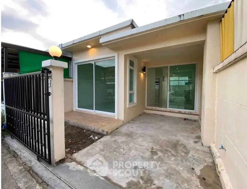 Charming single-story home with modern facade and spacious driveway in a serene neighborhood.