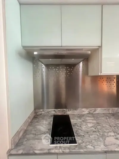 Modern kitchen with sleek marble countertop and built-in electric stove