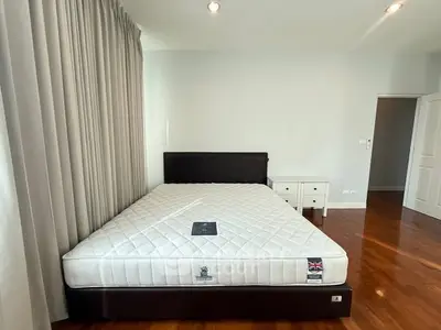 Spacious bedroom with elegant hardwood floors and modern furnishings