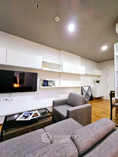 Modern living room with sleek furniture and wall-mounted TV in stylish apartment