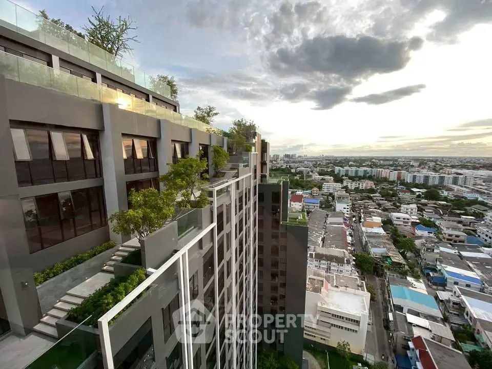 Stunning high-rise building with lush rooftop garden and panoramic city views at sunset.