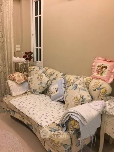 Charming living room with floral sofa and cozy decor, perfect for relaxation and comfort.