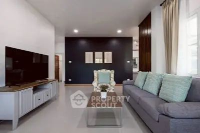 Modern living room with stylish furniture and large TV, perfect for relaxation.