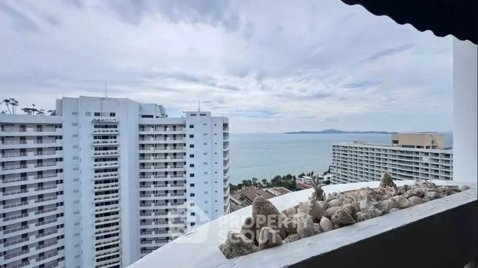 Stunning ocean view from high-rise balcony with nearby modern buildings.