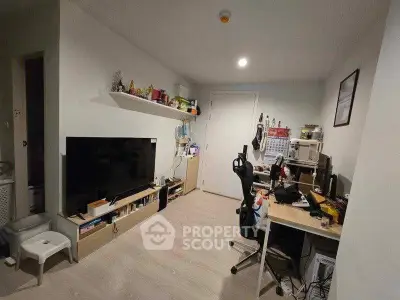 Modern study room with sleek desk, large TV, and ample storage in a cozy apartment.